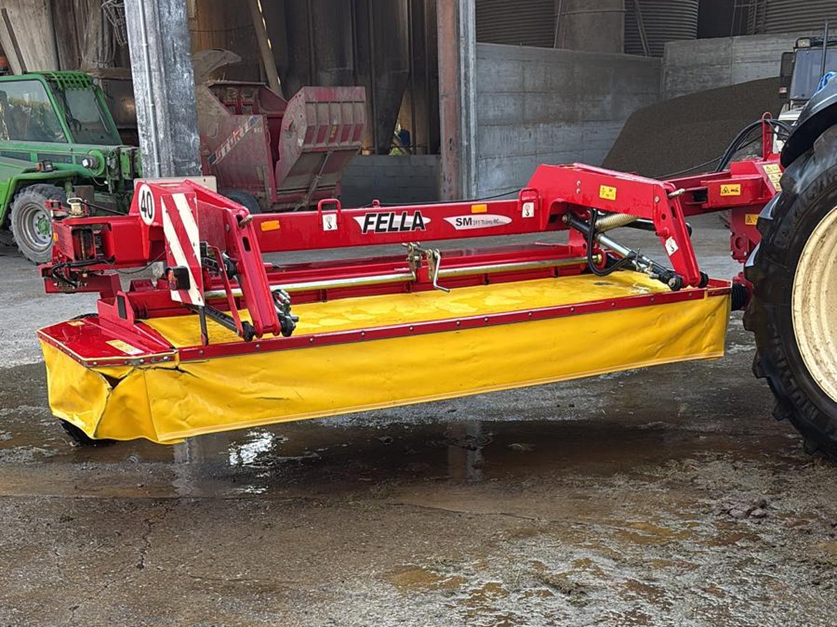 Falcia-condizionatrice rossa e gialla agganciata al trattore