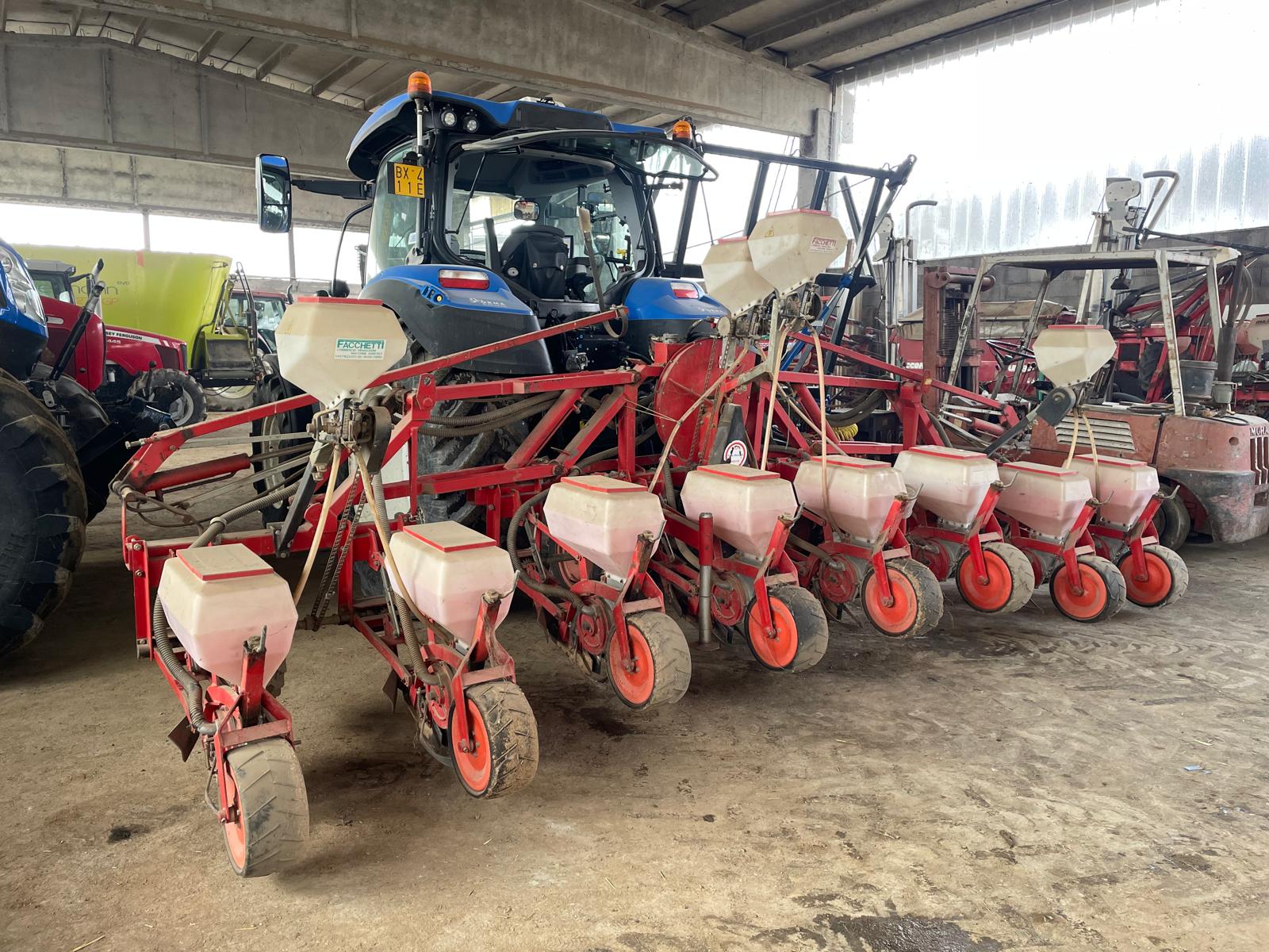 Seminatrice di precisione per mais agganciata al trattore sotto la tettoia